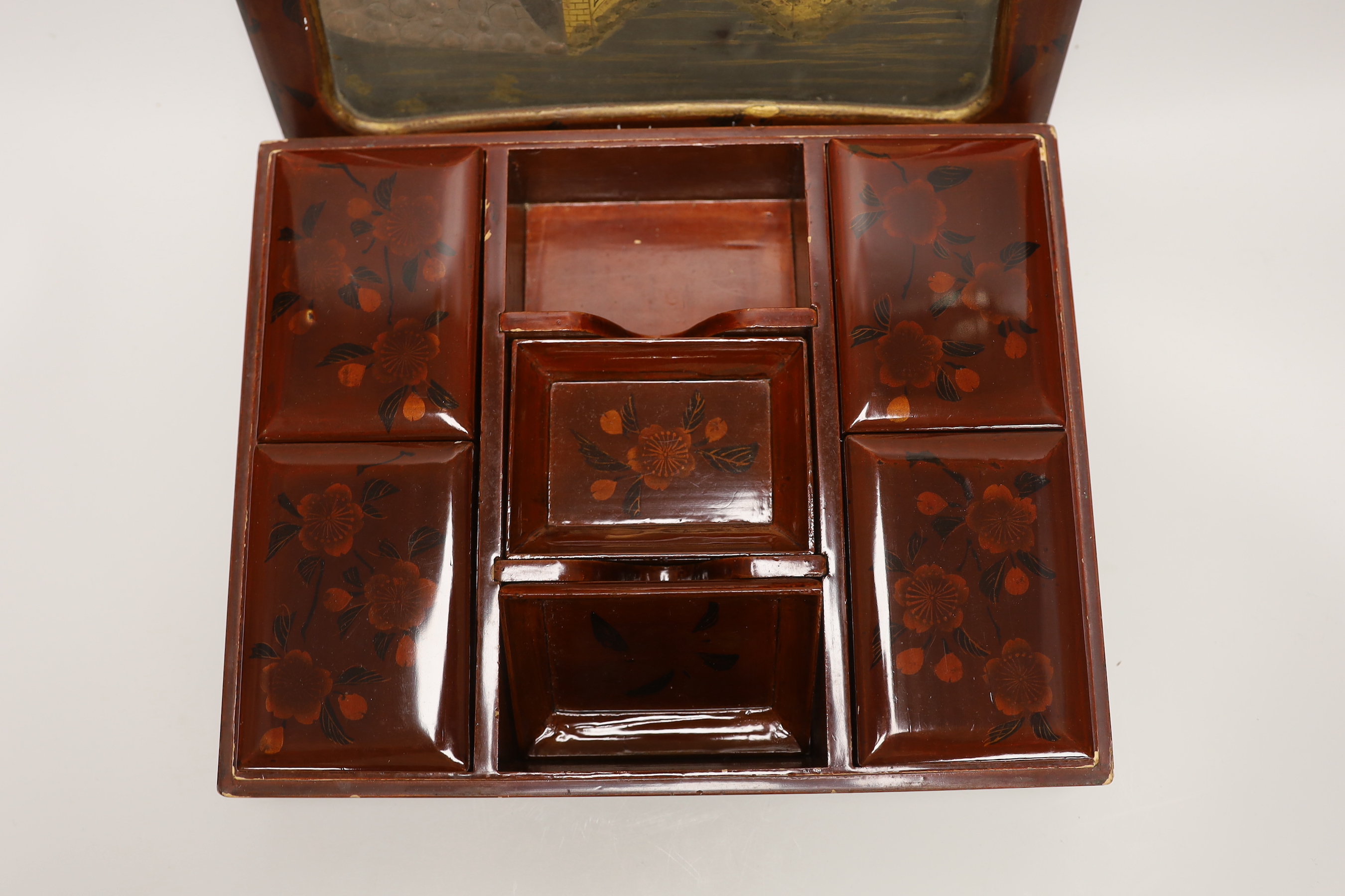 A Japanese lacquer games box, the cover having a central landscape painting together with a carved bamboo page turner, box 30 cm wide x 24 deep